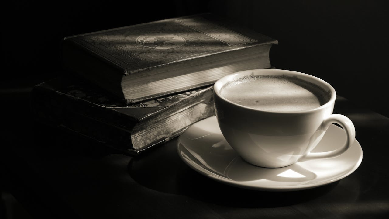 A close-up of a steaming cup of coffee with vintage books, set in a warm, sepia tone.