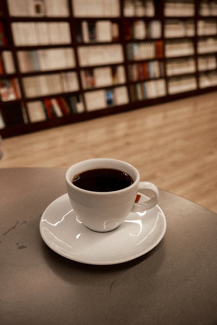 A warm cup of coffee on a table in a serene library ambiance.